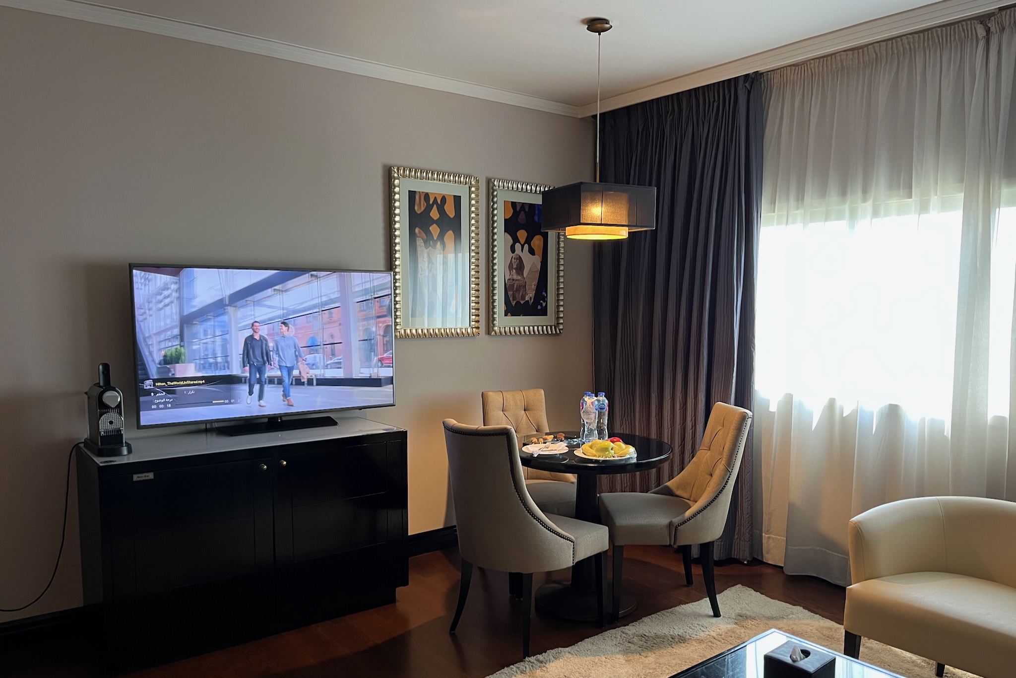 Small round table with three chairs, sideboard with large TV and minibar Kleiner runder Tisch mit drei Stühlen, Sideboard mit großem Fernseher und Minibar